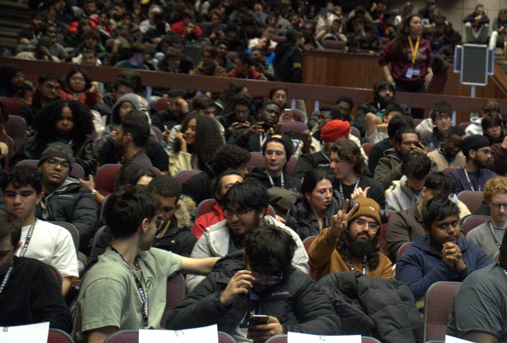 Picture of Sufiyan watching his phone, his teammates Abdulrahman Kikia, Dawoud Naseem and Daniel Ganchev, Rayyan Khan and Nayemur during ConUHacks 2026.